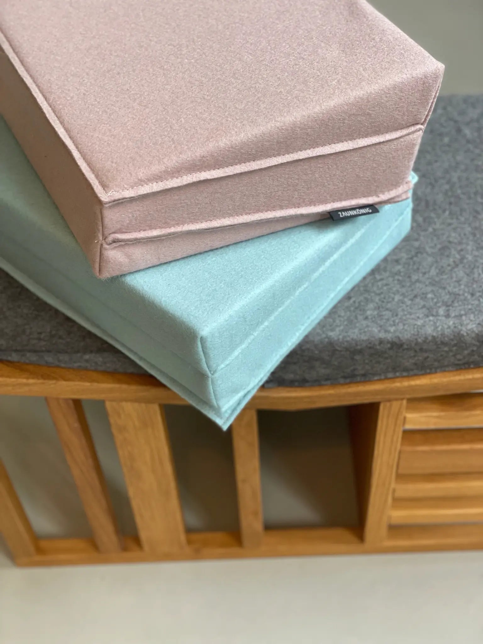 Sitzbank mit Faltpolstern aus Wollfilz in den Farben Elephant Grey, Mint und Powder.