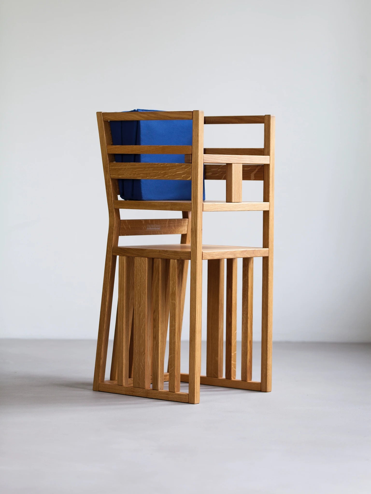 Der ZAUNKÖNIG Lernturm (3-in-1) als Hochstuhl mit Schritthalterung aus massivem Eichenholz mit Faltpolster aus Baumwolle (Midnight Blue); Seitenansicht.