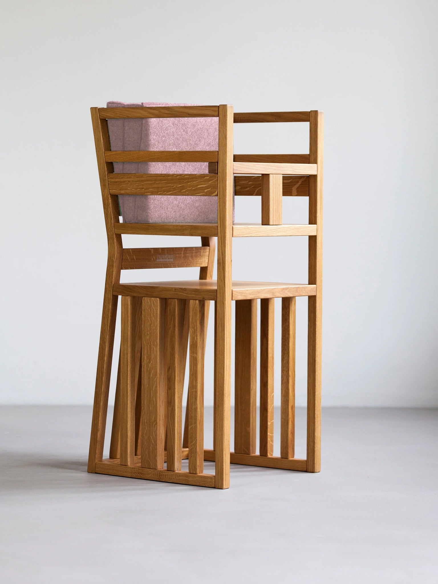 Der ZAUNKÖNIG Lernturm (3-in-1) als Hochstuhl aus massivem Eichenholz mit Schritthalterung für Kinder und Faltpolster aus Wollfilz in der Farbe Powder.