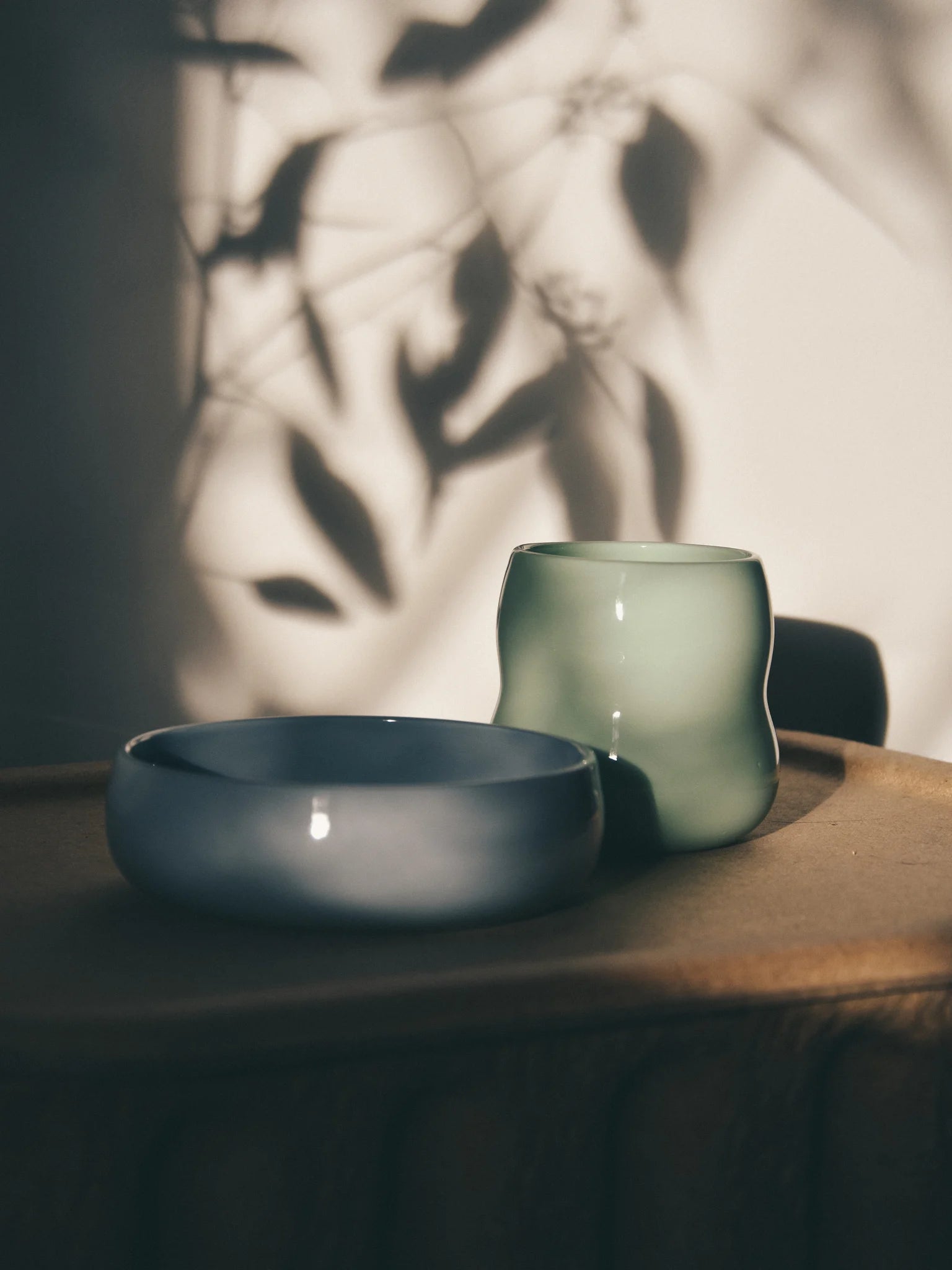 Kindergeschirr aus Porzellan im Schatten, Frontansicht des Kinderbechers in Agave und der Kinderschale in Kornblume.