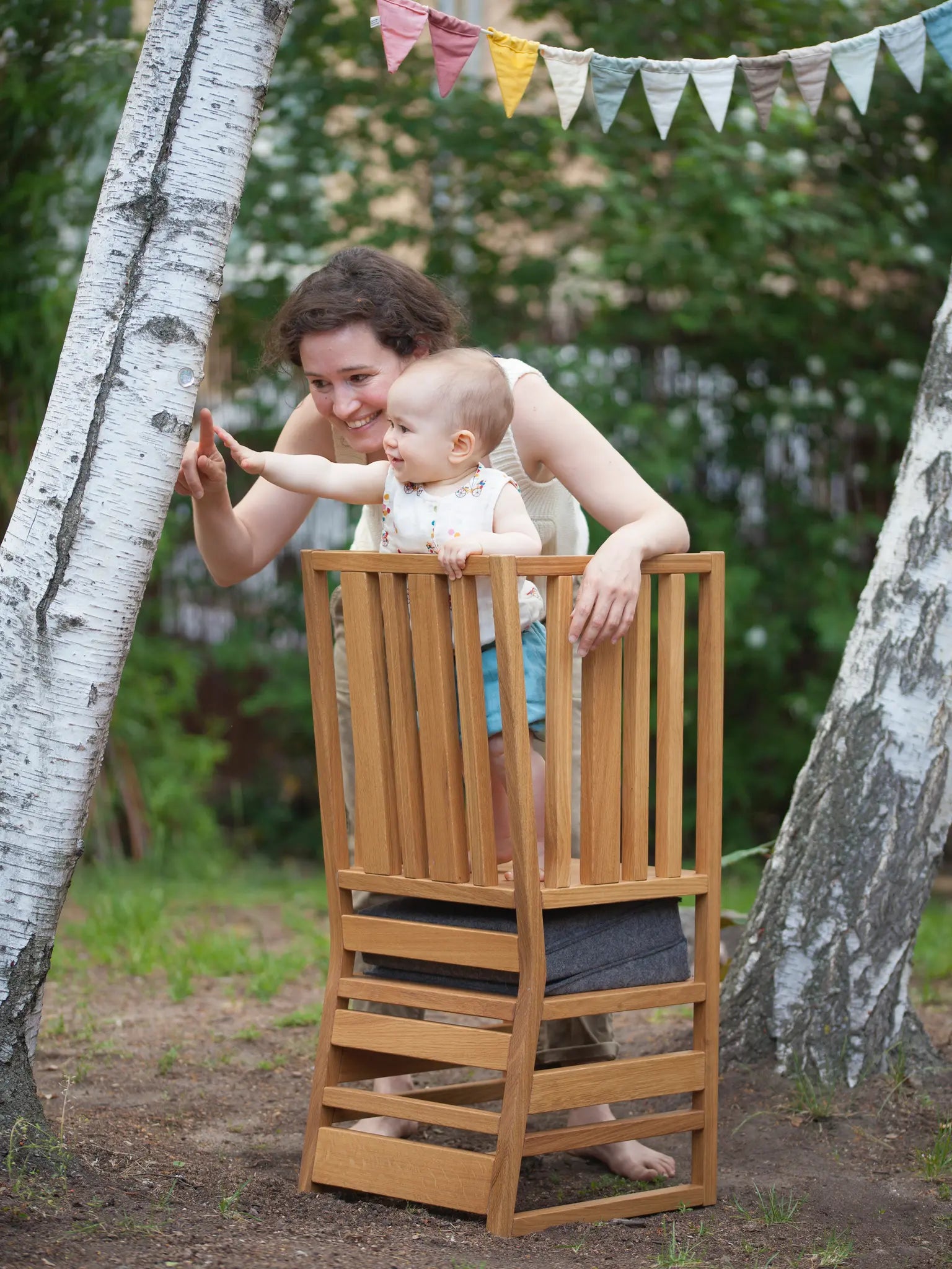 Der ZAUNKÖNIG® Lernturm mit Baby und Mama im Garten.