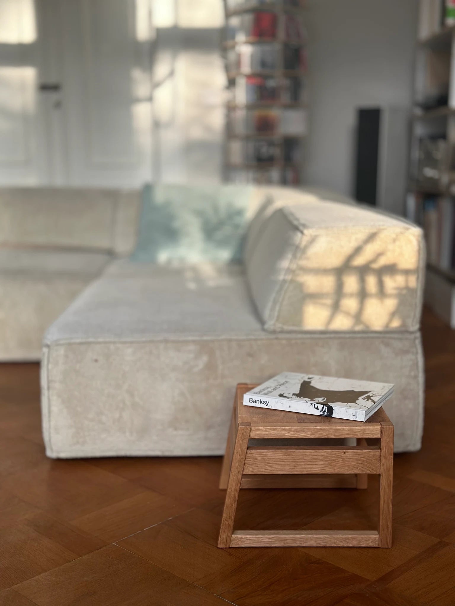 Der ZAUNKÖNIG Mini als Couchtisch im Wohnzimmer; Seitenansicht mit einem Buch.