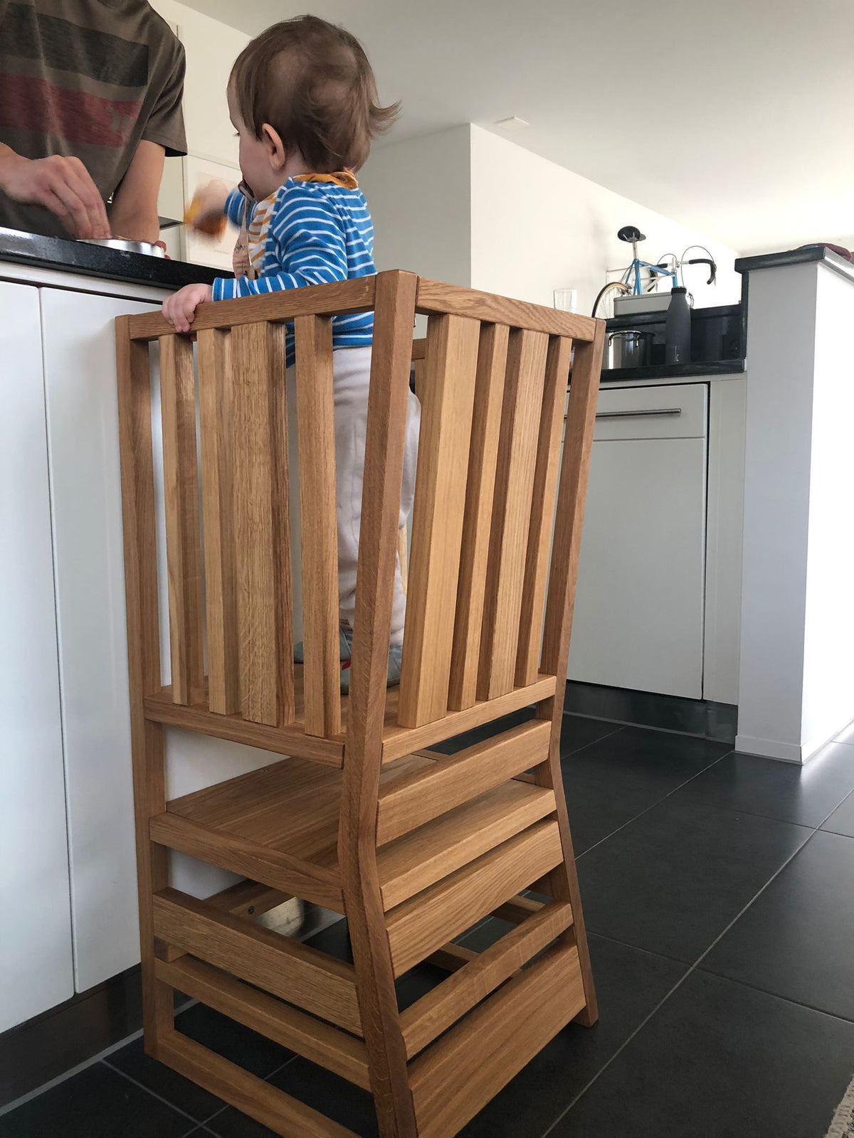 Kind steht im ZAUNKÖNIG® als Lernturm in der Küche
