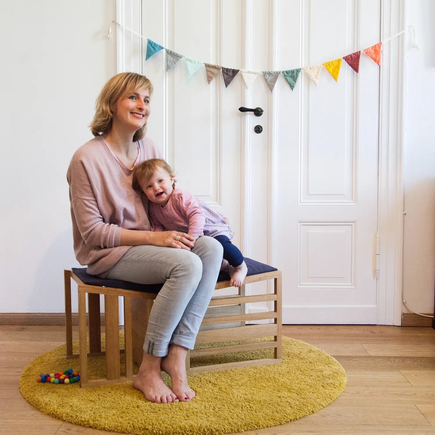 Der ZAUNKÖNIG Lernturm (3-in-1) aus massivem Eichenholz als Sitzbank, Seitenansicht mit Mutter und Kind.